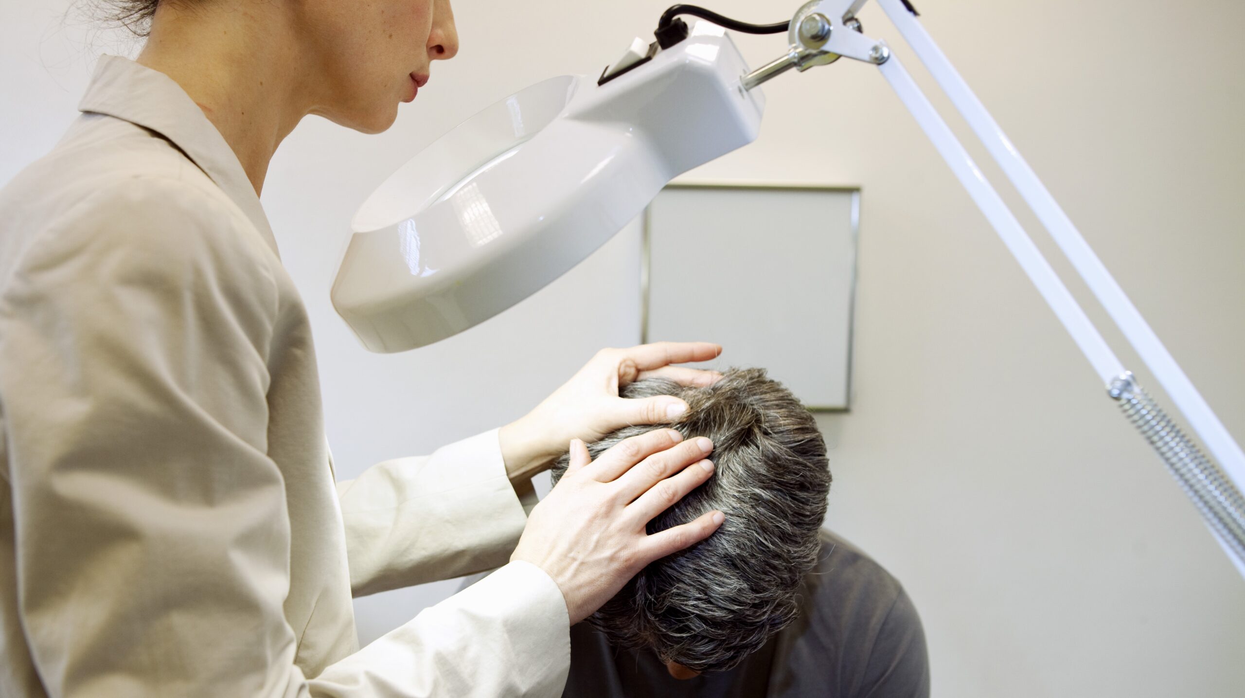 doctor examining teen with alopecia areata